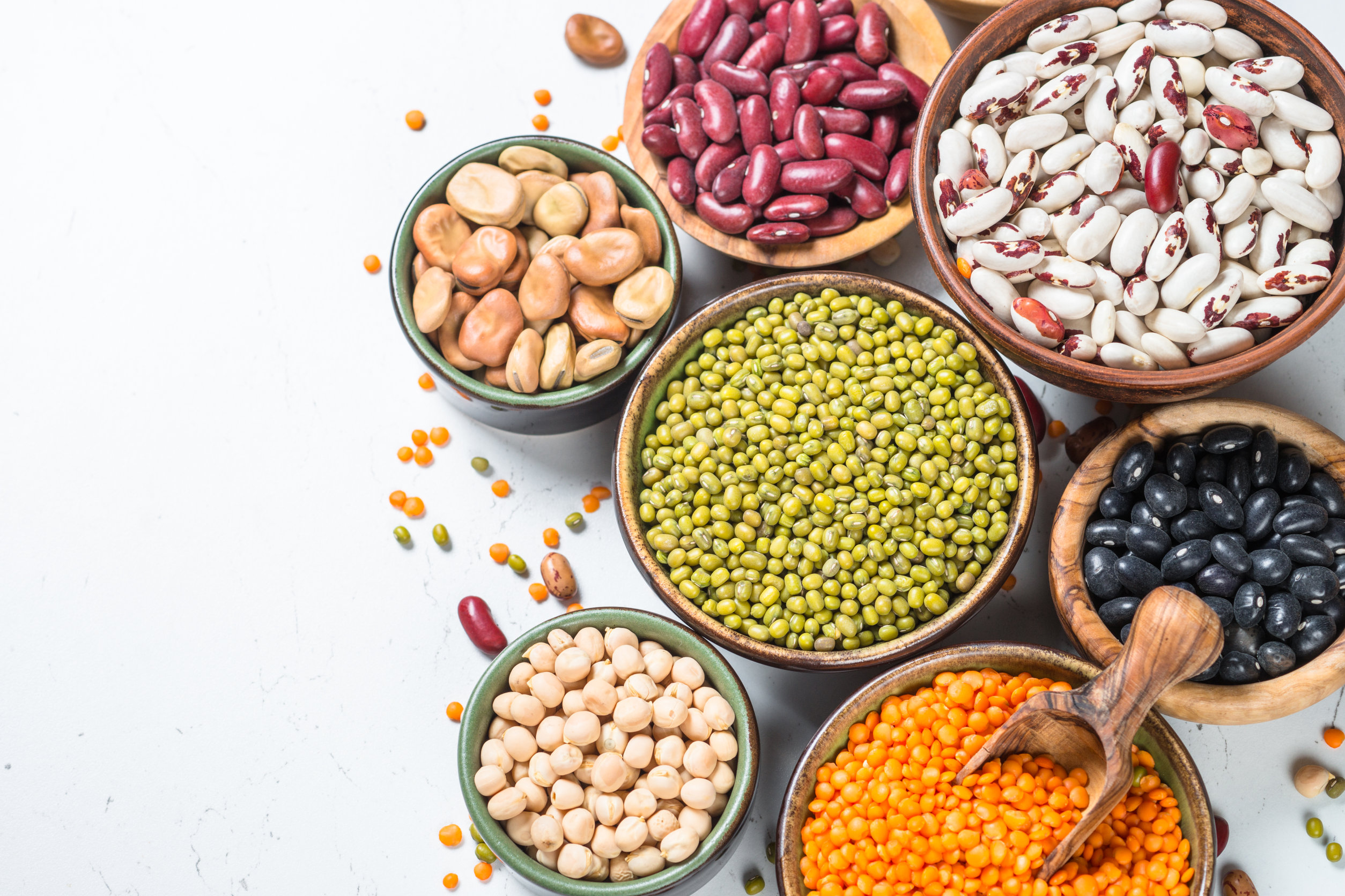 Legumes, lentils, chikpea and beans assortment on white.